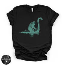 Load image into Gallery viewer, Bigfoot Riding Nessy Tee | Funny Cryptid Graphic T-Shirt