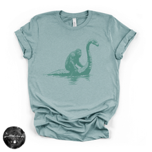 Load image into Gallery viewer, Bigfoot Riding Nessy Tee | Funny Cryptid Graphic T-Shirt
